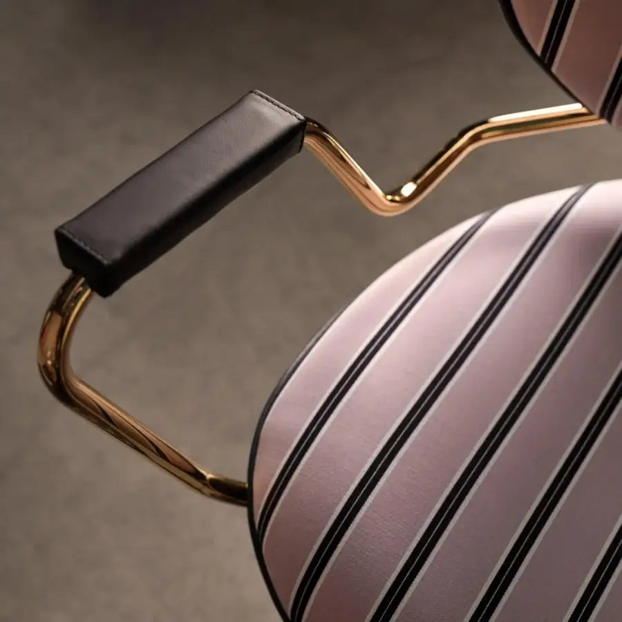 Superior Black Tie Asia swivel lounge chair upholstered in mauve, cream, and dark gray striped textile with polished gold metal armrests