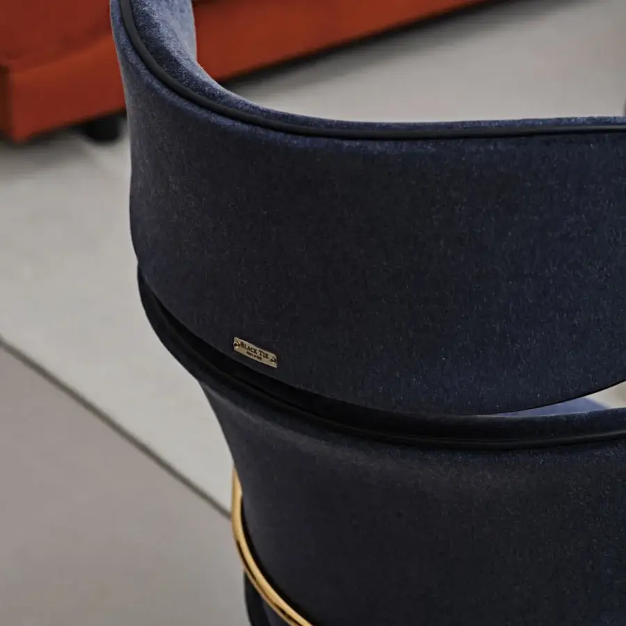 Lavish Black Tie Asia swivel lounge chair upholstered in velvety dark blue textile with gold-toned metal accents