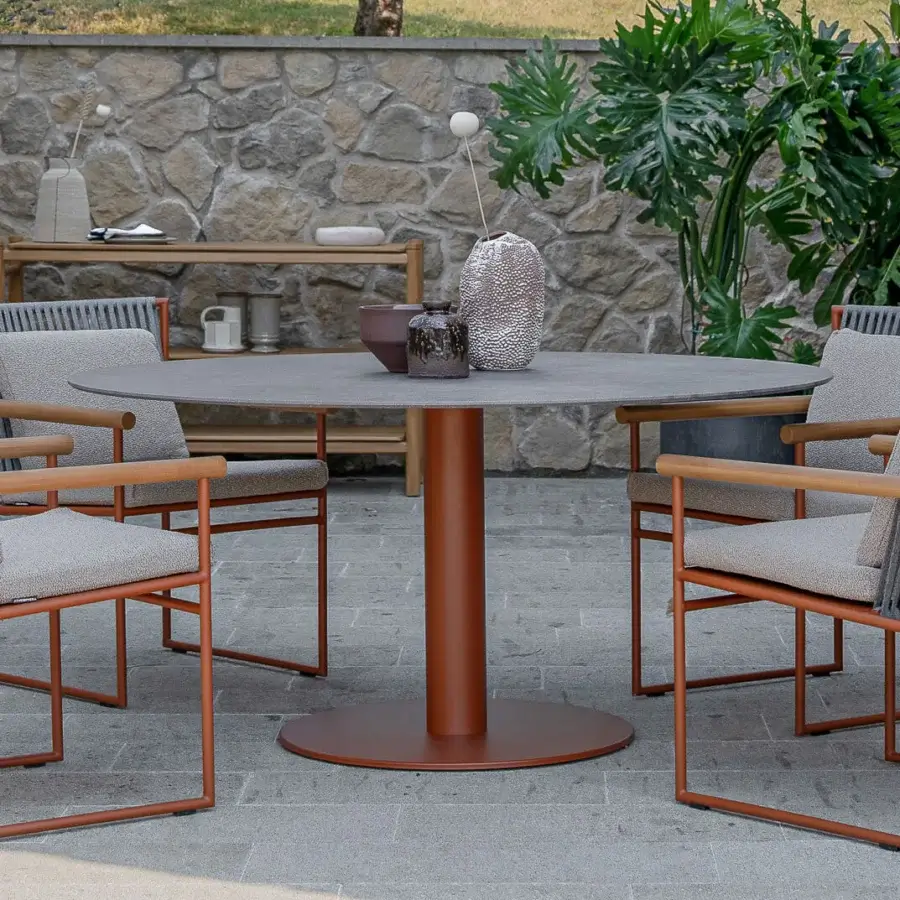 Superior Atmosphera Arena round table with smooth medium gray gres and reddish-brown cylindrical base construction