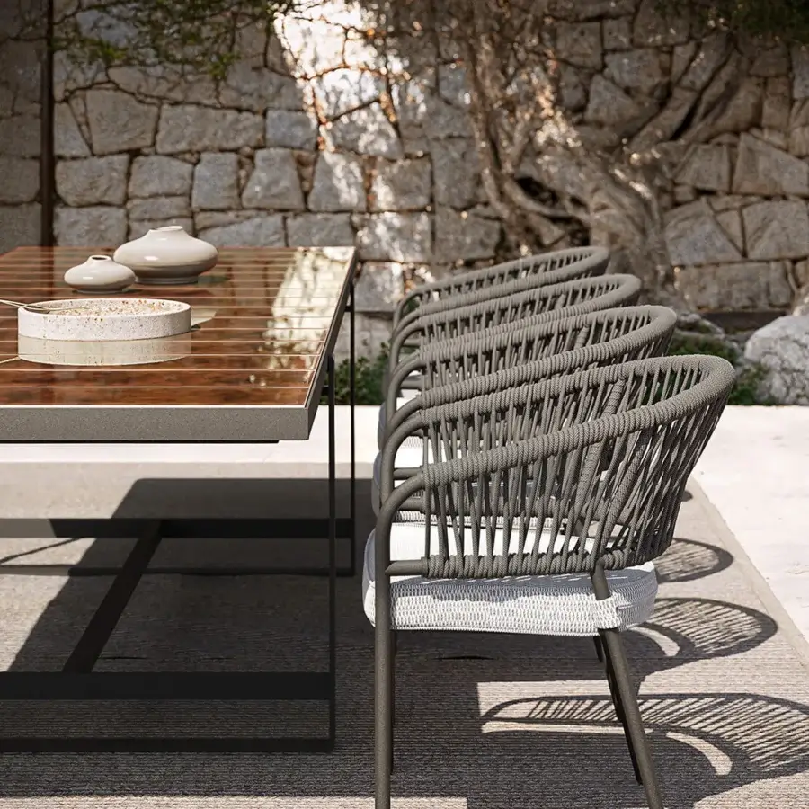 Superior Atmosphera Capri table built with warm brown textured lava stone slats and a dark gray solid aluminum base