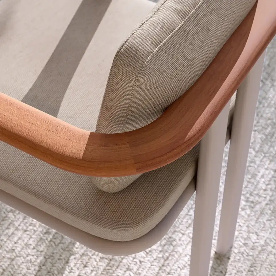 Elegant Atmosphera Bliss armchair crafted with Gesso aluminum, natural teak armrests and neutral beige textured textile cushions