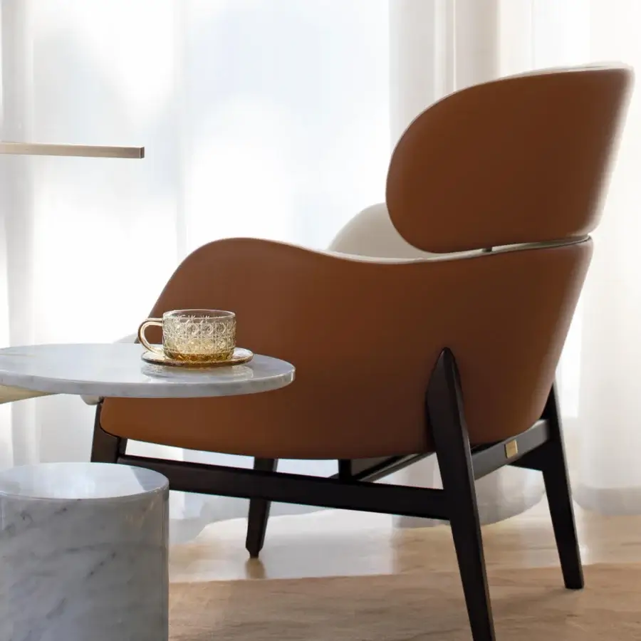 Refined Capital Dafne lounge chair with curved form and warm medium-brown textile upholstery crafted with a dark matte wooden frame