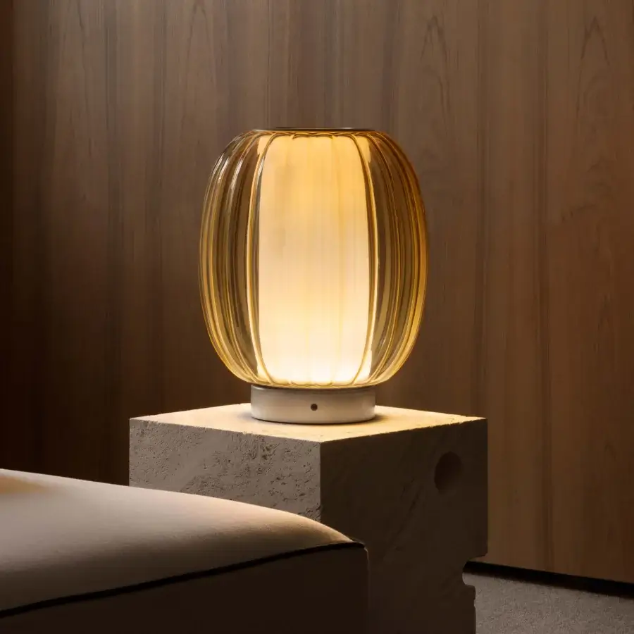 Distinguished Contardi Alma lamp crafted in warm amber blown glass with a dark brown fabric cable and smooth white base