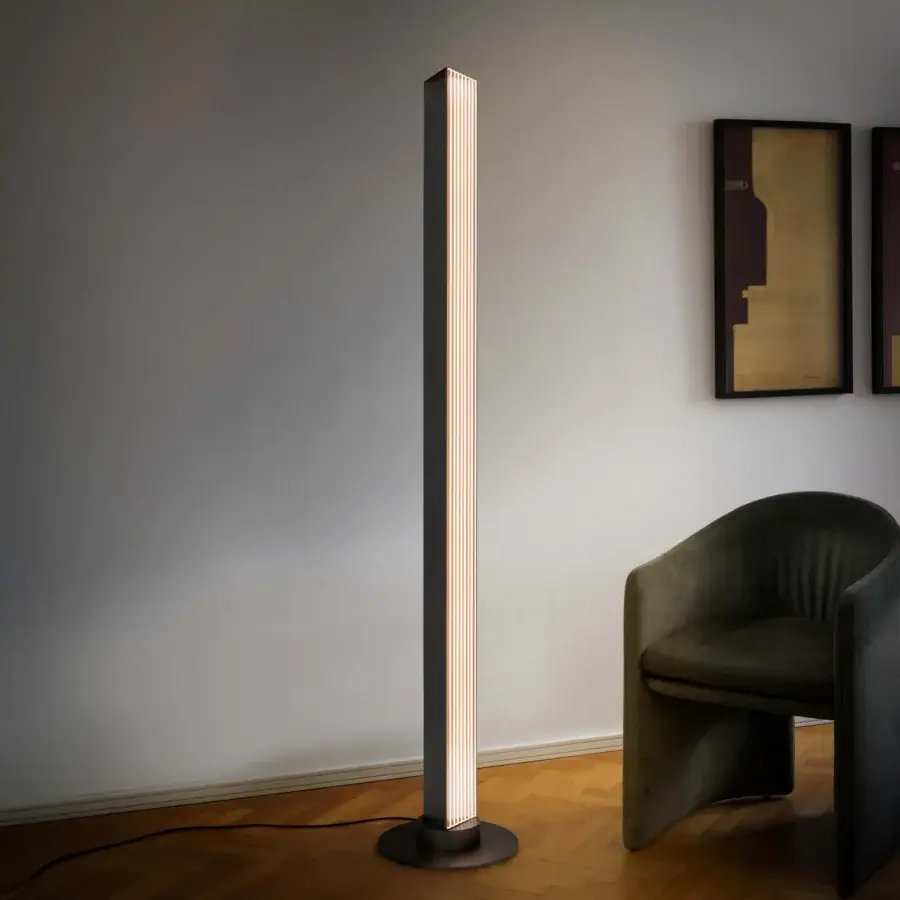 Distinguished Contardi Stick floor lamp with slender matte black metal frame and warm diffused ribbed glass illumination
