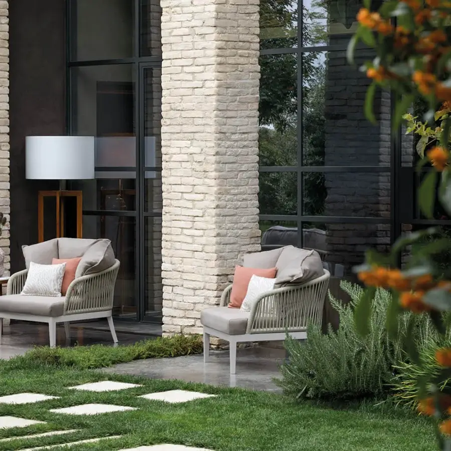Elegant Atmosphera Dream 2.0 lounge chair crafted with light-colored metal, neutral gray fabric and inviting peach cushions