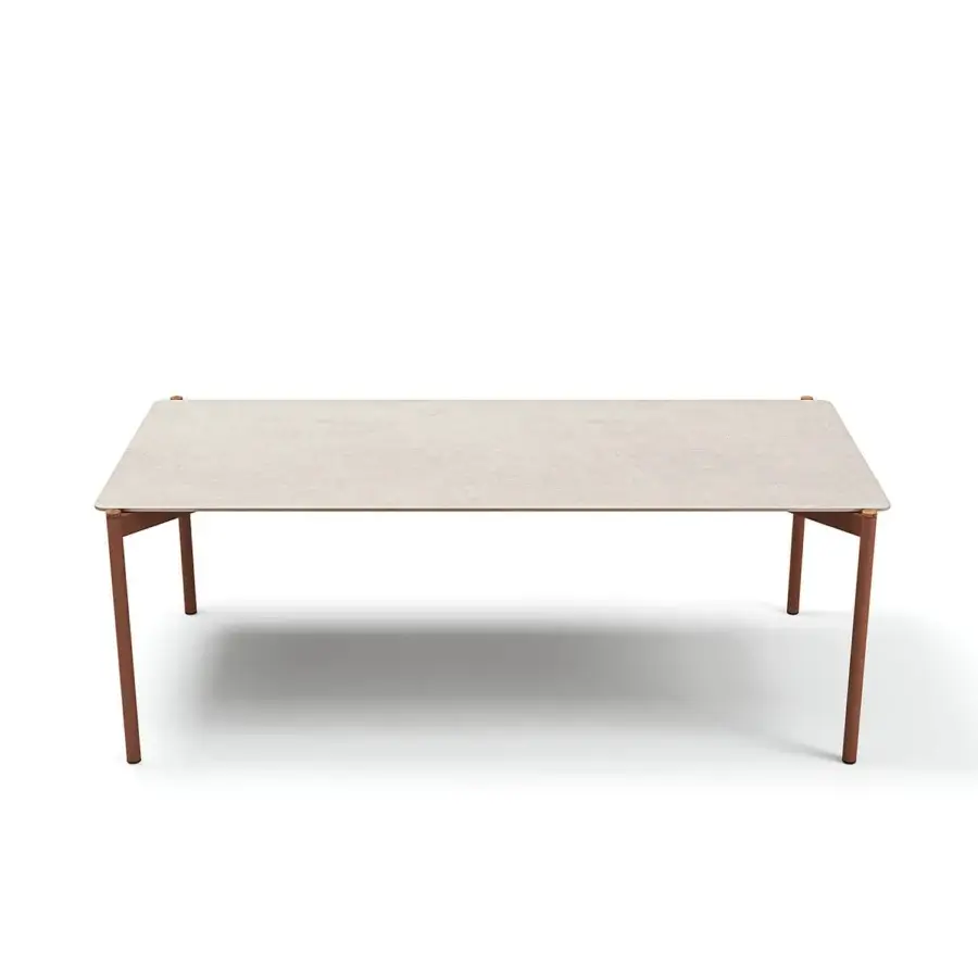 Elegant Atmosphera Heritage table with a textured gres tabletop and cylindrical aluminum legs accented with warm teak details in a matte finish