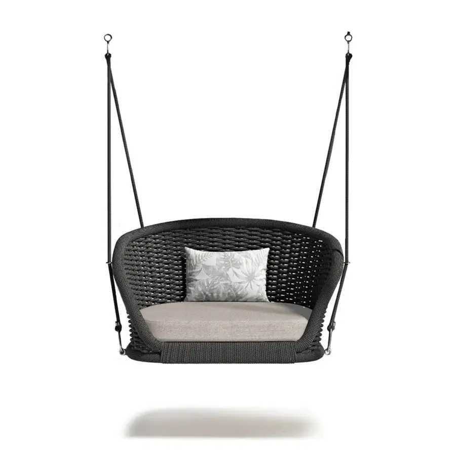 Distinguished Atmosphera Ludo swing with a dark gray hand-woven material and tactile rope suspension complemented by a pale botanical cushion