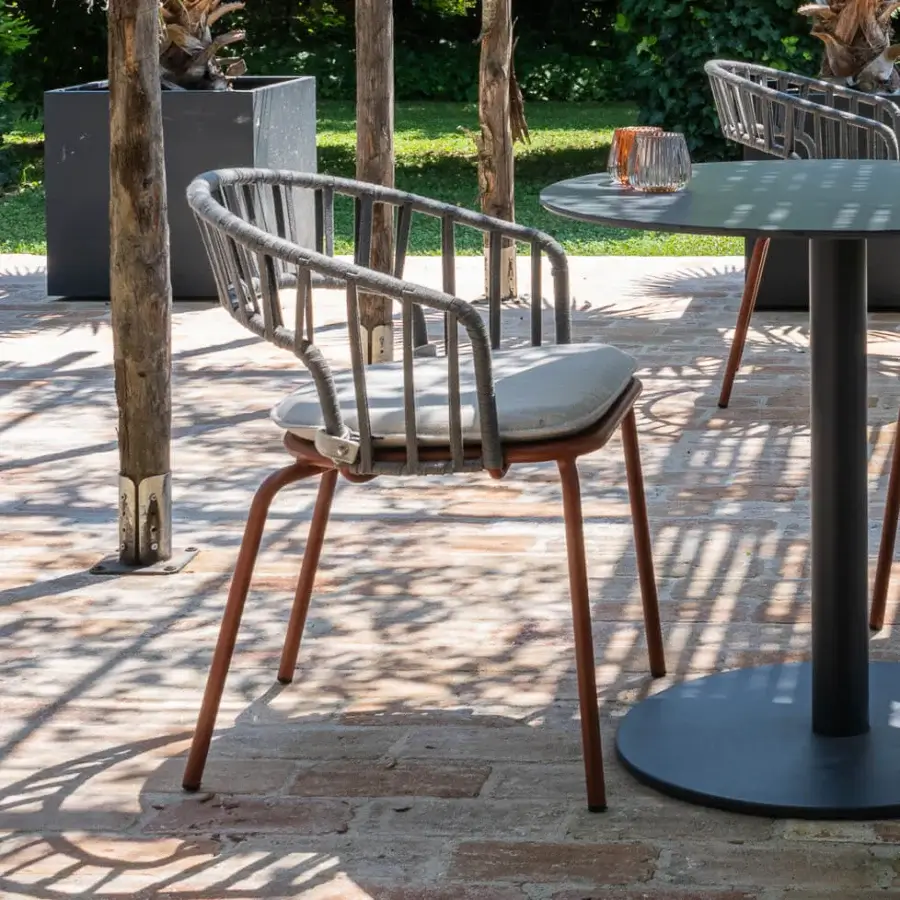 Distinguished Atmosphera Onda armchair with gracefully curved silhouette and braided light gray textile with reddish-brown coated metal frame
