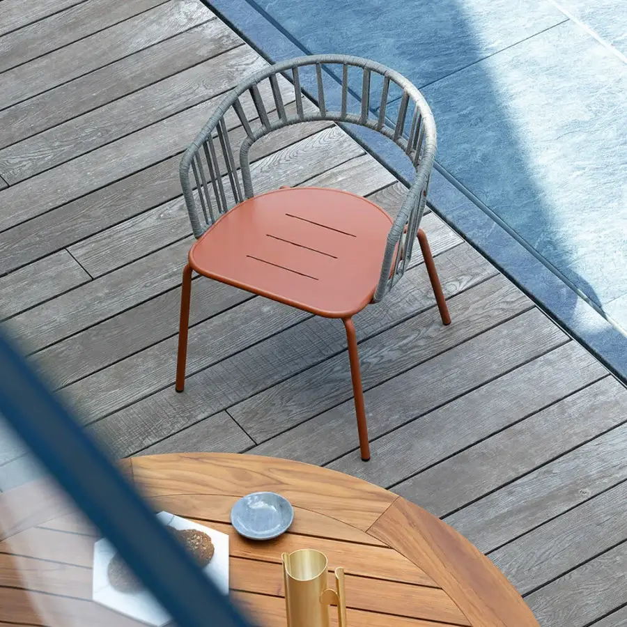 Elegant Atmosphera Onda armchair with curved silhouette and reddish-brown matte metal frame built with textured grey textile backrest