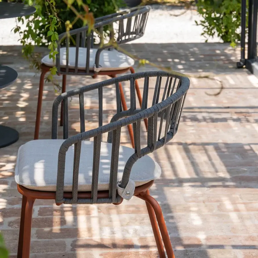 Captivating Atmosphera Onda armchair with curved silhouette and braided backrest crafted in reddish-brown metal with light gray woven textile