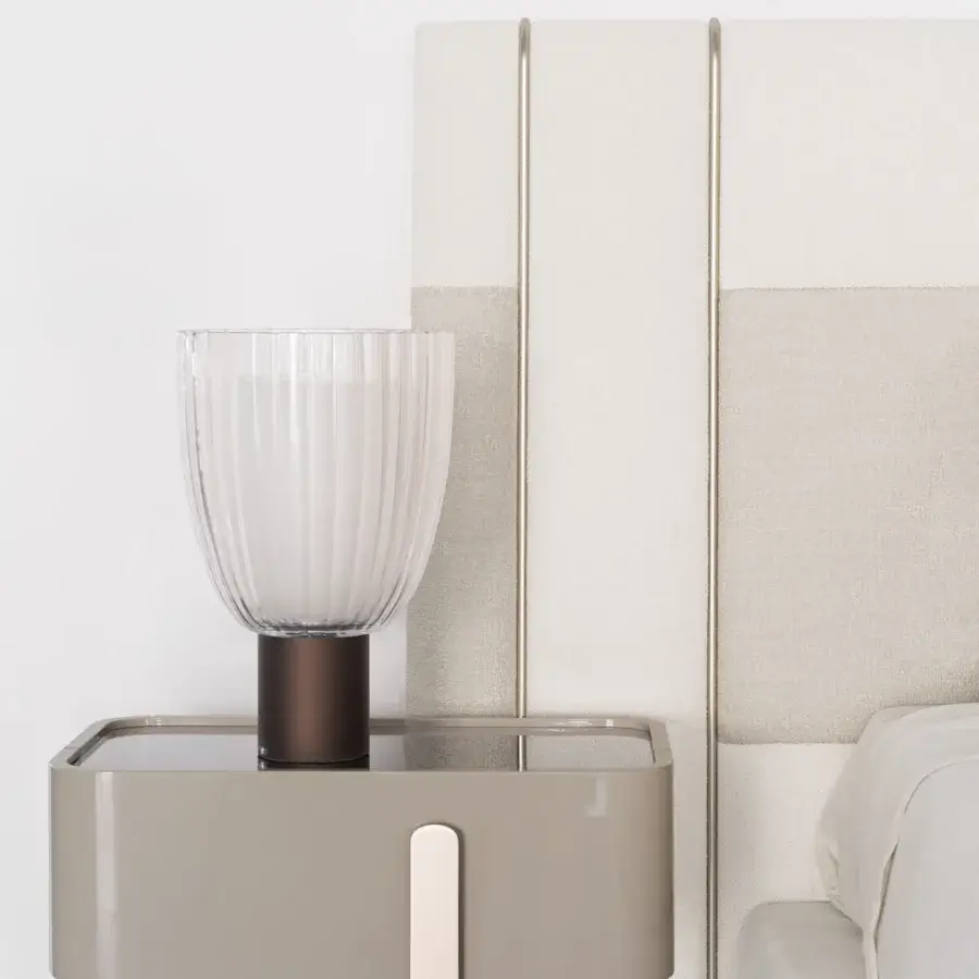 Elegant Capital Eden nightstand with a gently rounded lacquered silhouette, muted taupe tone and glossy glass tabletop with gold-toned metal legs