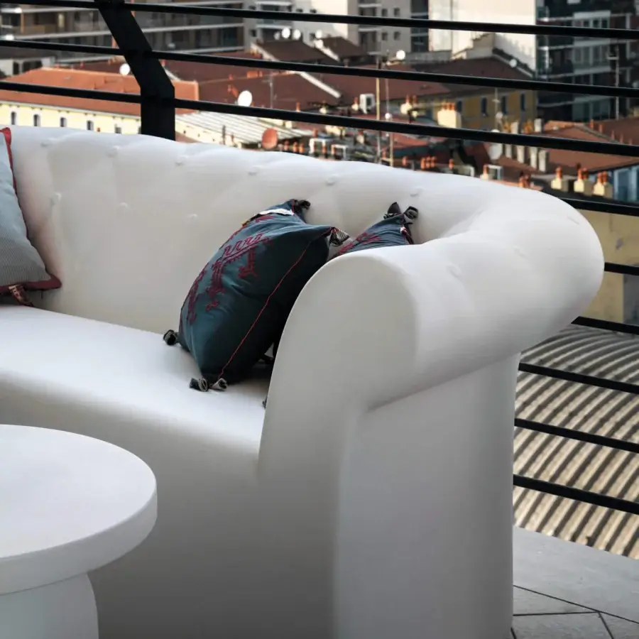 Elegant Serralunga Sirchester sofa molded from glossy white LLDPE plastic with vibrant teal cushion and red embroidery