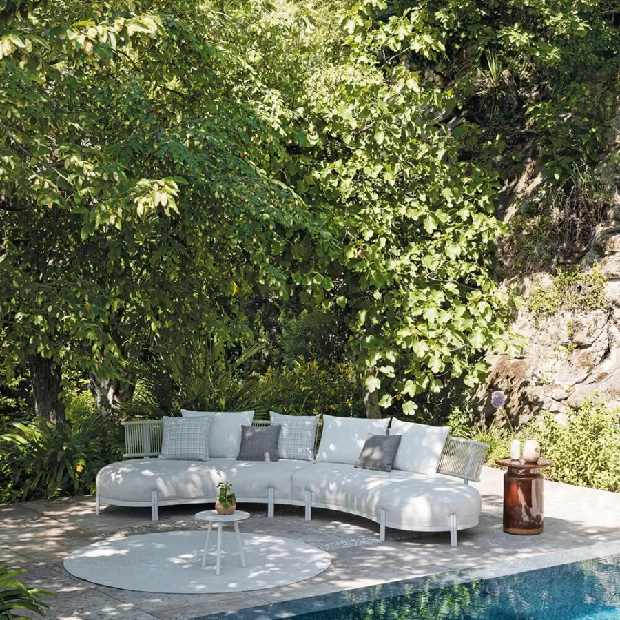 Distinguished Atmosphera Loto sectional with a gracefully curved silhouette upholstered in smooth, light neutral, high-performance textiles crafted for outdoor use