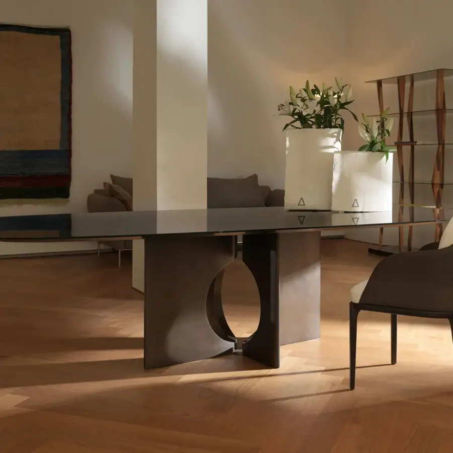 Exceptional Horm Brion table with cool glass tabletop and sculptural dark bronze-toned metal base exhibiting a central opening