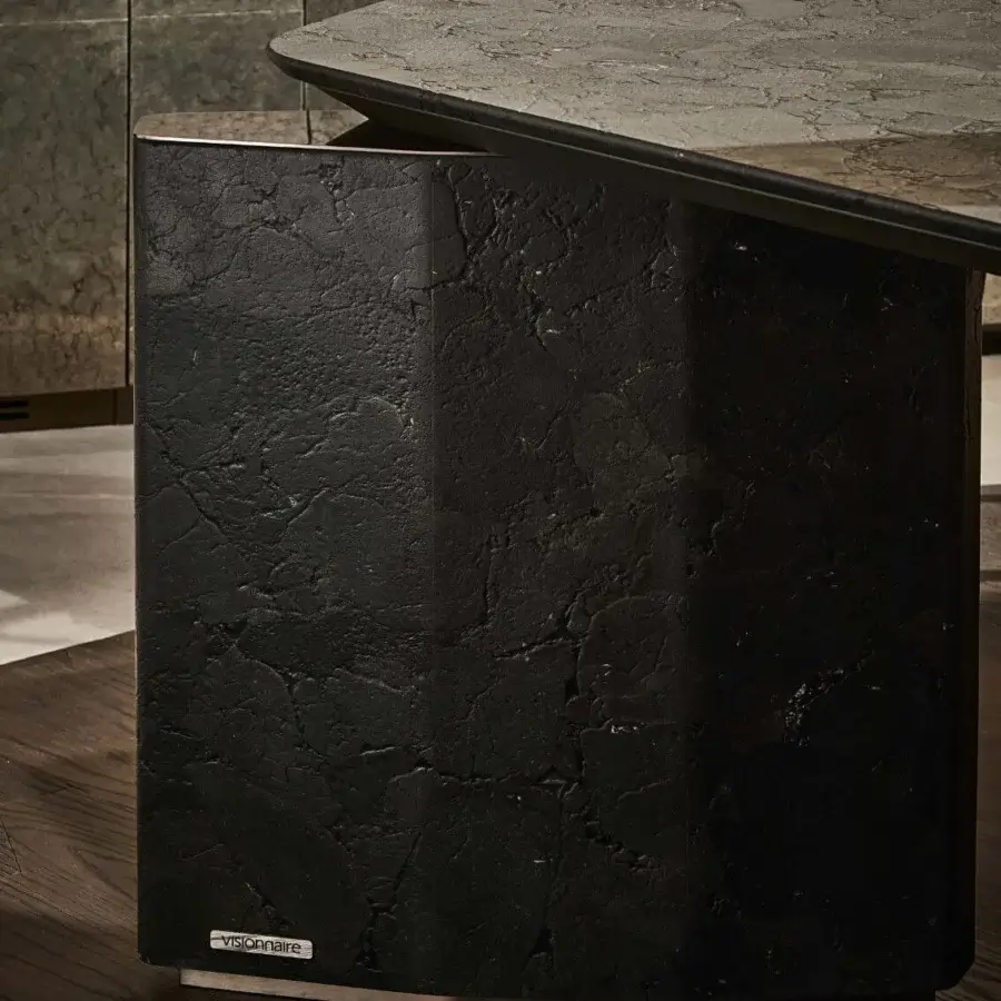 Luxury Visionnaire Titan Table with polished marble top, charcoal translucence, matte black stone base, silver trim, logo plaque
