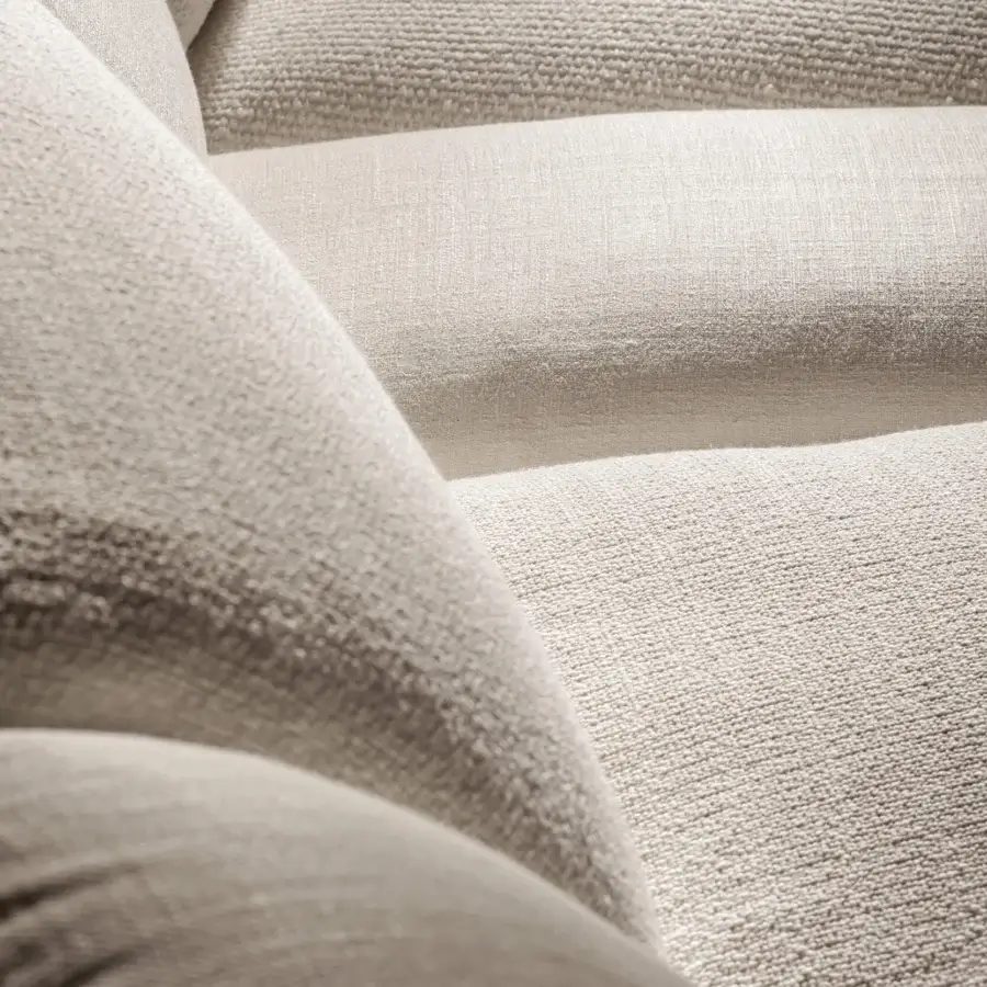 Luxury sectional in LAGO fabric with matte off‑white to light‑cream finish, curves, cushions, and contrasting textured textile