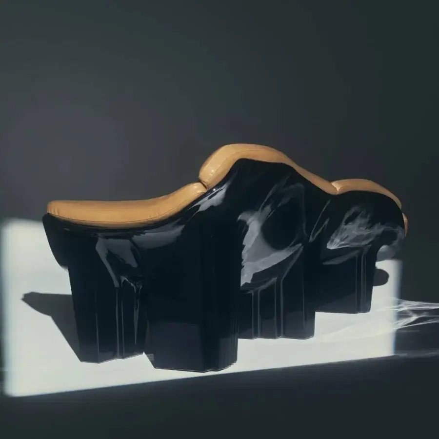 Elegant Visionnaire Blob sofa in glossy black lacquer shell with tan leather‑like upholstery, acrylic felt support, fluid interior