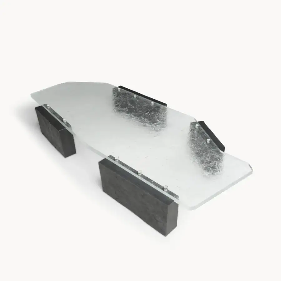Elite coffee table with Moltrasio stone base, translucent glass top, palladium‑finished brass studs, black metal rail