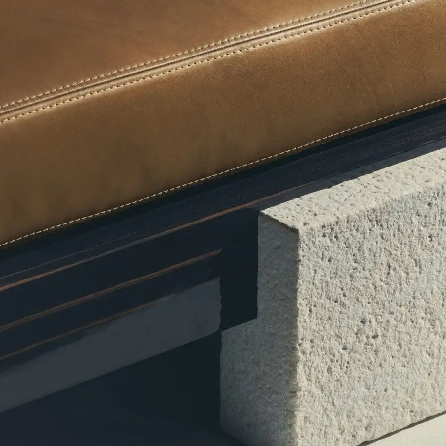 Luxury Visionnaire Stealth sofa with camel‑brown upholstery, dark veneered frame, rough stone base and Memory Foam core