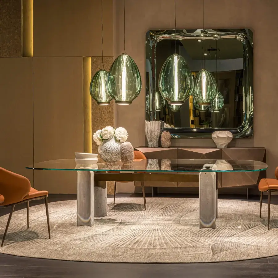 Luxury Cattelan Italia Bilbao Glass Table with oval transparent glass top supported by cement pillars and matte stone finish