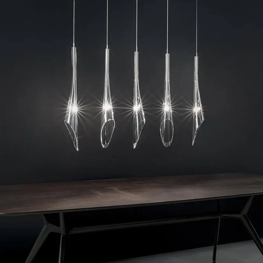 Distinguished Terzani Calle suspension lamp with transparent glass components and glossy metallic cables emitting warm light