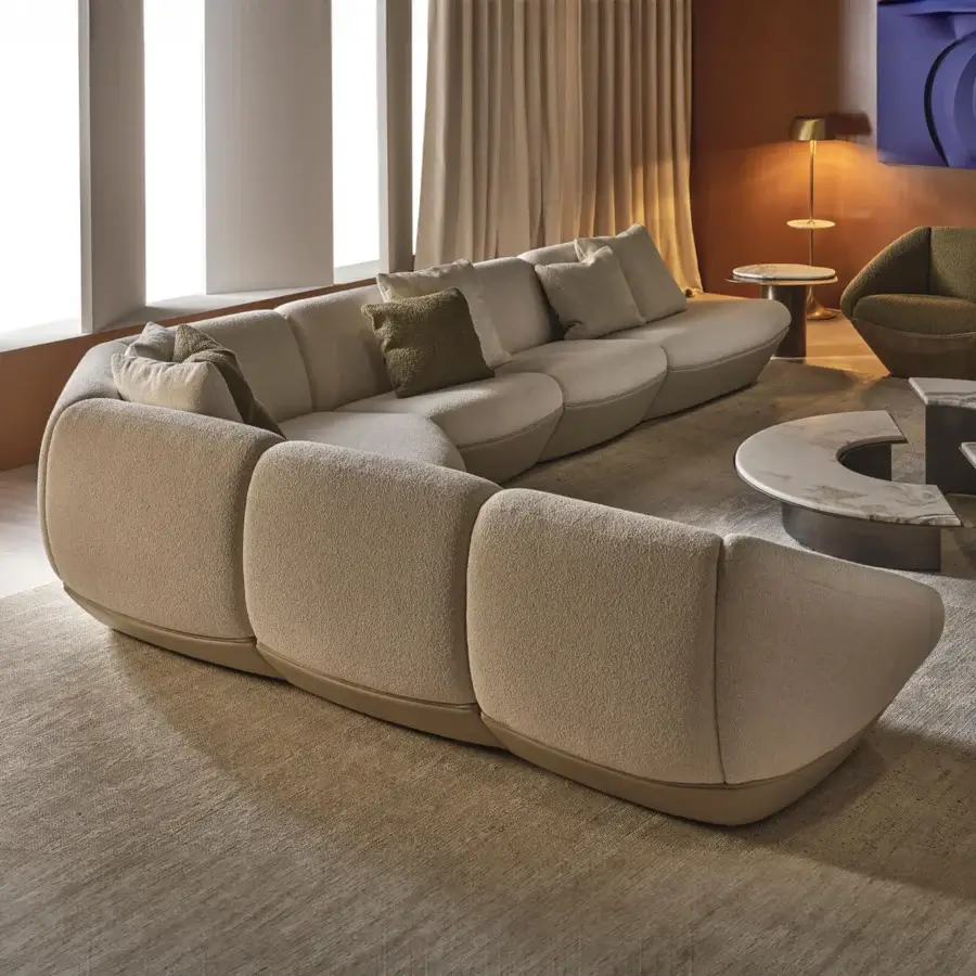 Elegant Rugiano Iside sectional low‑profile semi‑circular silhouette textured textile leather‑like accents bronzed brass beige‑taupe fabric with darker borders olive‑green pillows curved modular construction