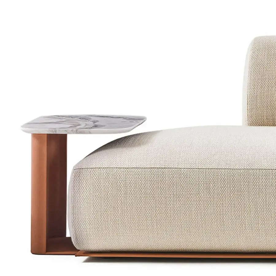 Elegant Rugiano Hatton sectional with leather‑wrapped base, copper‑toned spine, marble side table and light‑cream upholstery