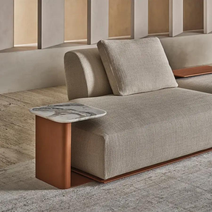 Contemporary Rugiano Hatton sectional with taupe textile, leather‑wrapped base, and copper‑toned L‑shaped side table on marble