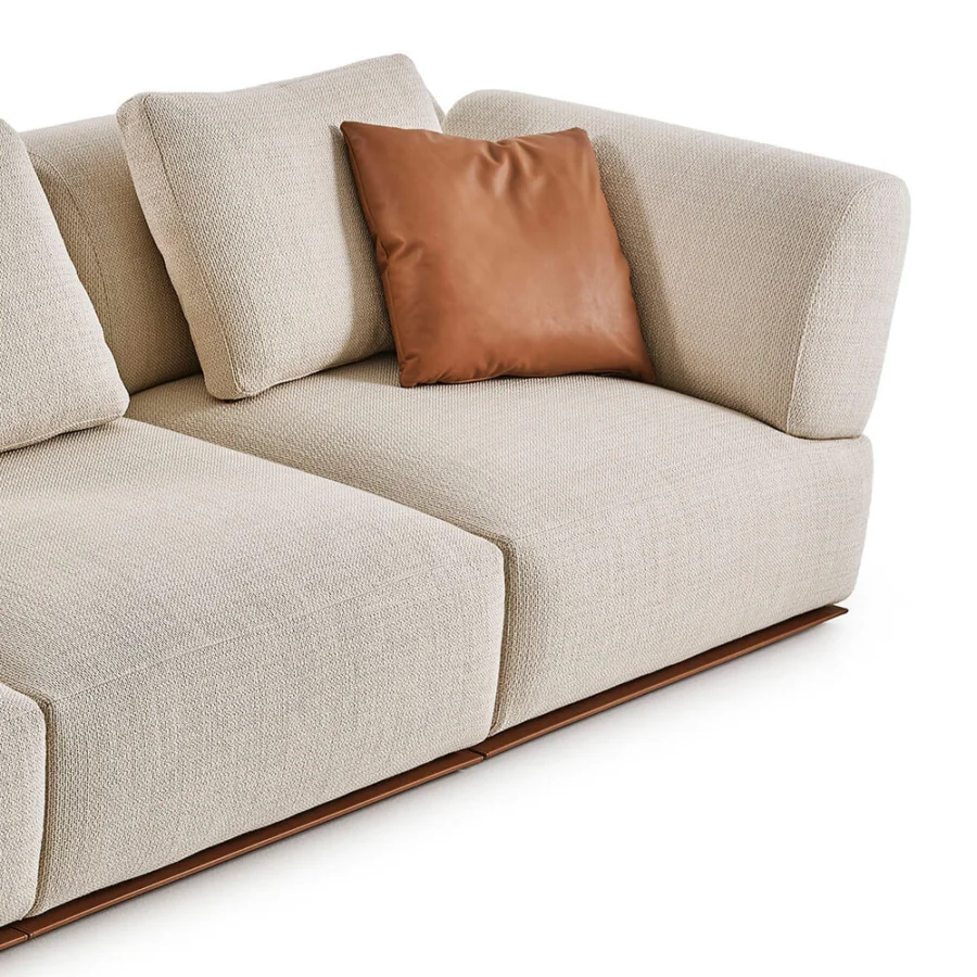 Luxury Rugiano Hatton sofa upholstered in off‑white fabric matte finish with brown leather pillow and recessed wooden base