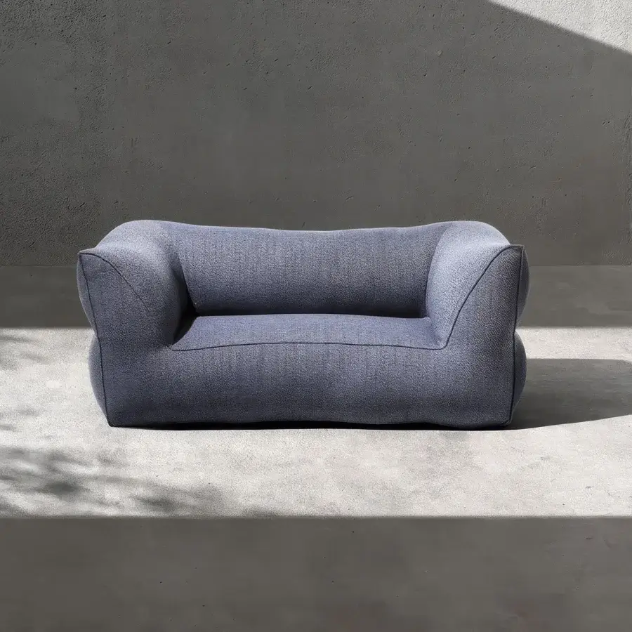 Premium Gart Puffone sofa with muted blue-grey outdoor fabric and matte grainy texture, low-profile wide silhouette