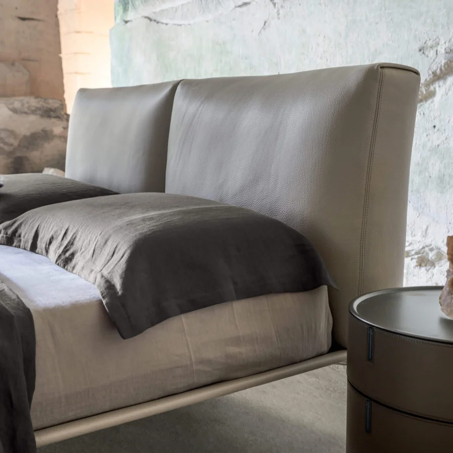 Luxury Alivar Papilon Bed with voluminous taupe-grey leather headboard and floating painted aluminium legs