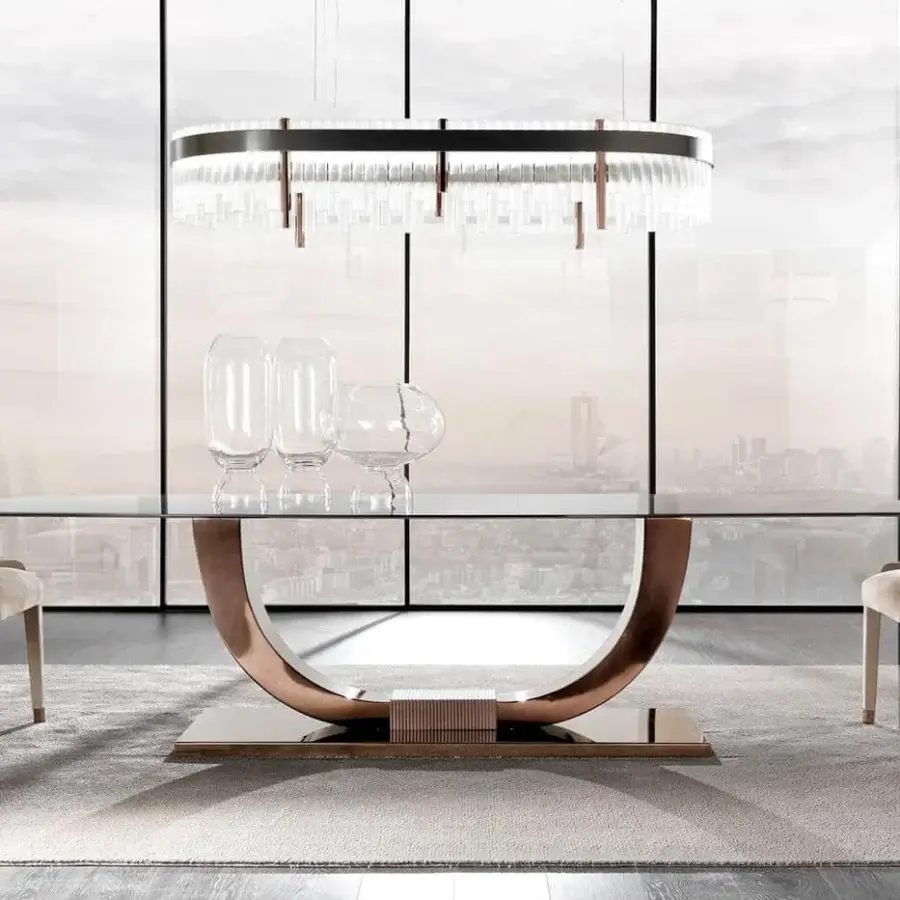 Innovative DV Home Collection Heritage table with clear glass top and curved stainless steel base in glossy bronze or copper finish