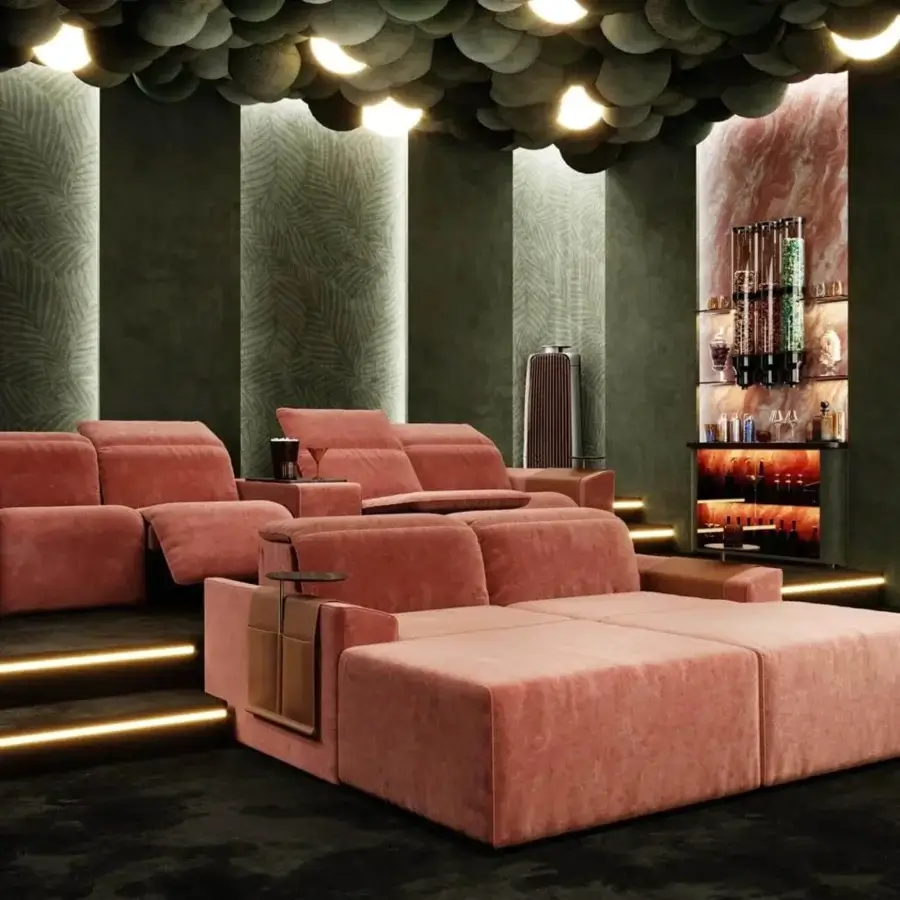 Refined Vismara Kubrik home cinema seating upholstered in salmon-pink textile with dark platforms and attached wooden tables