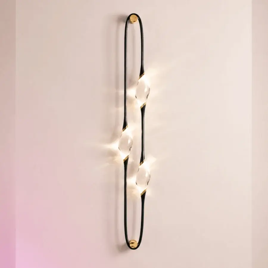Sophisticated Il Pezzo 12 wall lamp with matte black wrought frame, glossy brass rings and handcrafted crystal diffusers