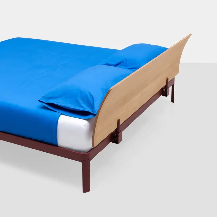 Premium Kristalia AluAlu Bed with lacquered deep‑red metal frame, light natural‑wood headboard blue textiles on white base