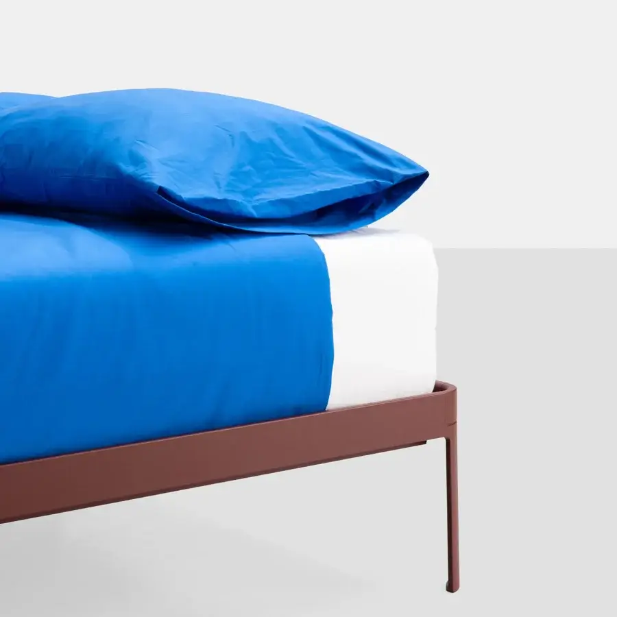 Elegant Kristalia AluAlu Bed with lacquered metal frame in warm brownish‑red hue, angular design and clean geometry