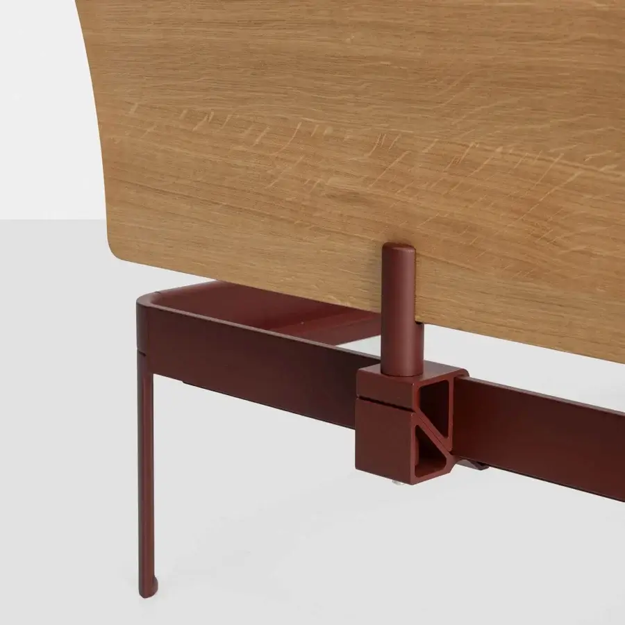 Elegant Kristalia AluAlu bed with light‑brown natural wood panel and deep burgundy matte metal frame, slender cylindrical leg