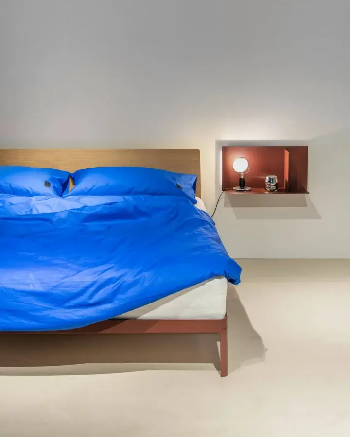 Sophisticated Kristalia AluAlu Bed with natural-grain wood headboard, Argilla matte frame and terracotta-tinted metal legs