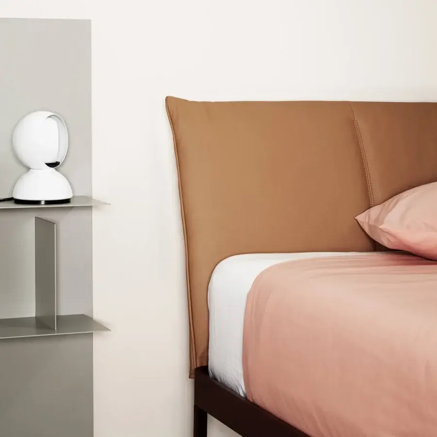 Elegant Kristalia AluAlu Bed with matte black aluminum frame, construction, warm tan leather‑like headboard, centerpiece