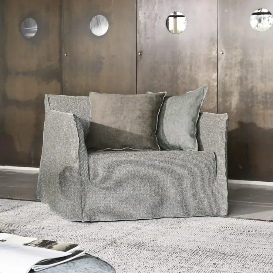 Luxury Gervasoni Ghost lounge chair with frame, matte finish, grey salt‑and‑pepper upholstery, plus sage‑green cushions