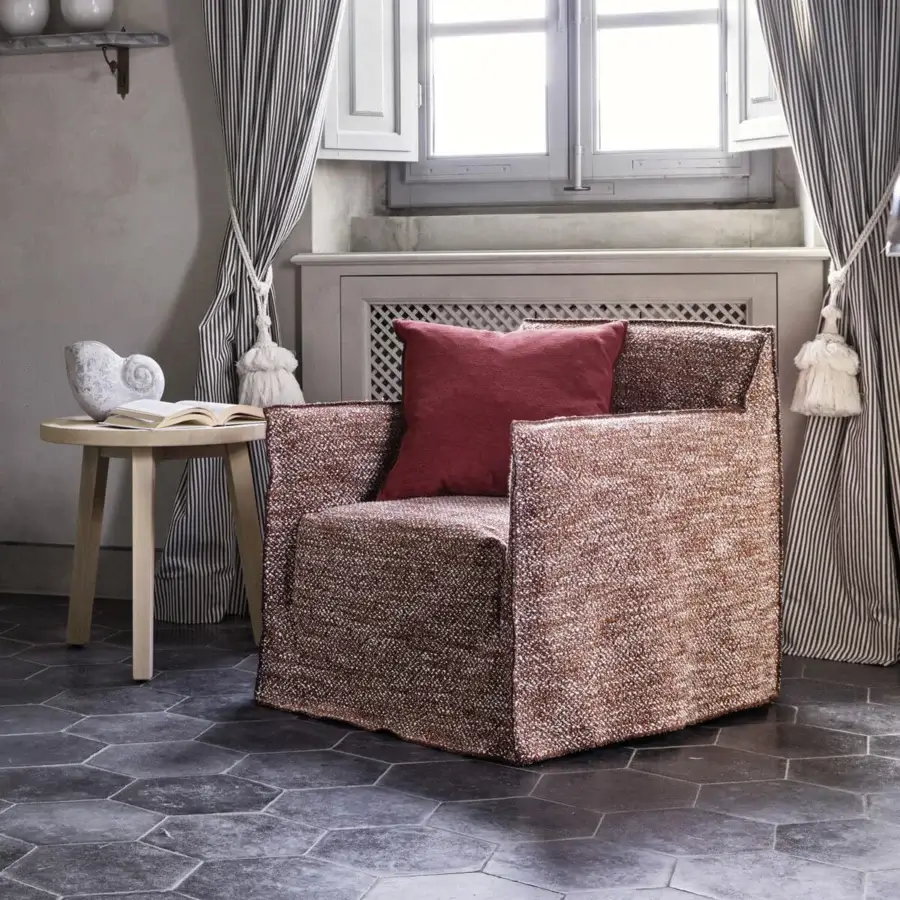 Luxury Gervasoni Ghost lounge chair with slim minimalist frame, textured removable cover in variegated reddish‑brown and white speckles, deep‑red seat cushion, blocky contemporary silhouette.