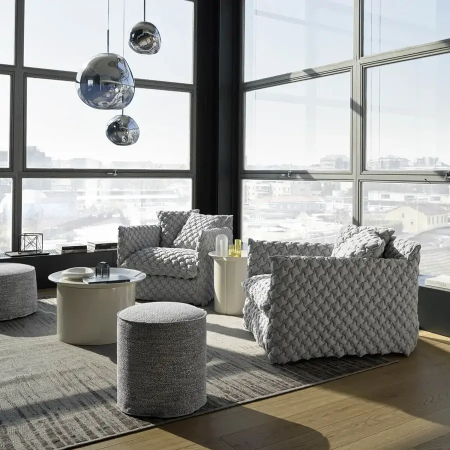 Luxury Gervasoni Ghost lounge chair in light‑gray quilted textile with seamless, textured finish, silhouette, arms