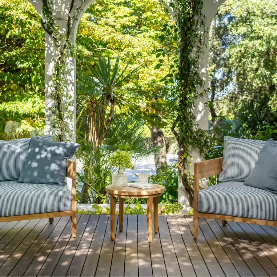 Fine Braid Feeling lounge chair with honey-brown teak frame and white striped textile cushions plus muted blue-grey pillow