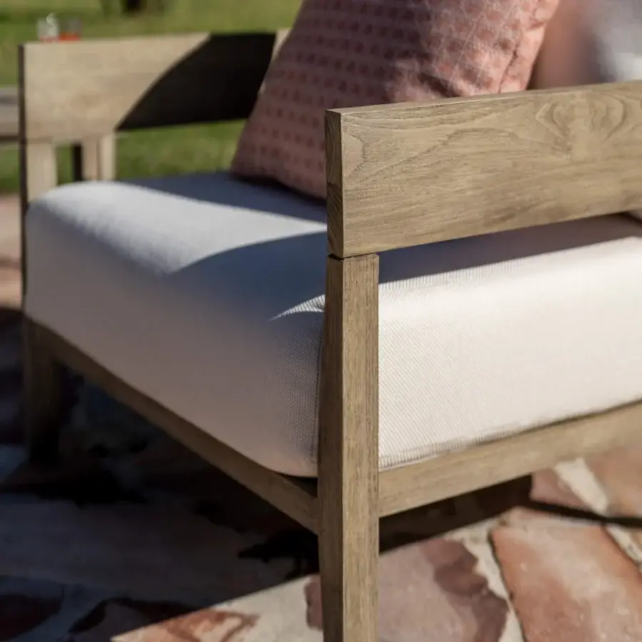 Luxury Braid Feeling lounge chair with teak frame and off‑white woven cushion, terracotta‑tinted pillow, matte finish