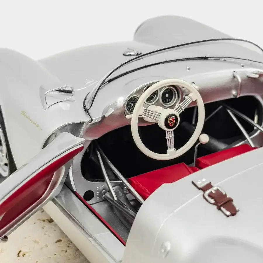 Timeless Vèlle Milano Porsche 550A Spyder model in glossy silver metal with rich burgundy interior and natural marble base