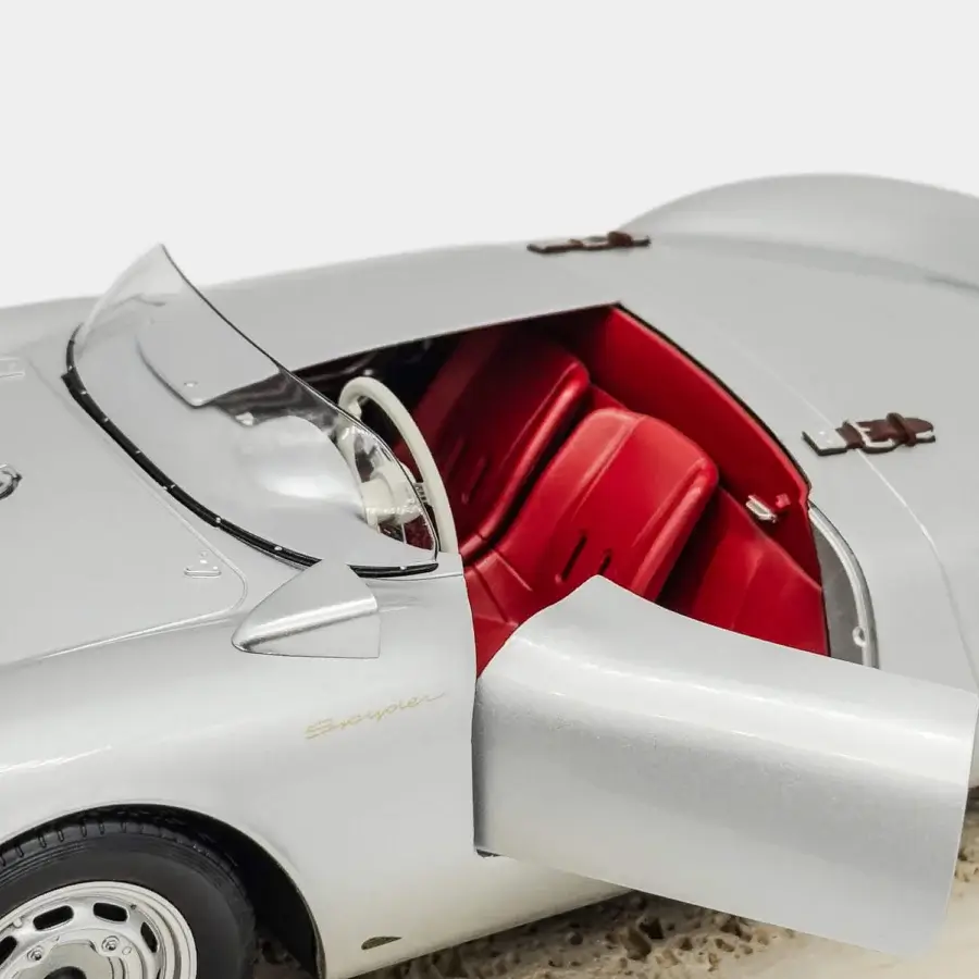 Distinguished Vèlle Milano Porsche 550A Spyder model in silver metal with burgundy interior and natural marble base
