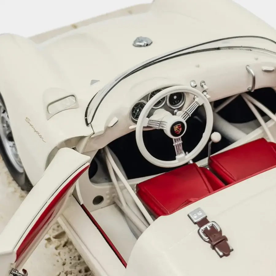 Distinguished Vèlle Milano Porsche 550A Spyder model in creamy white metal with vibrant red interior and natural marble base