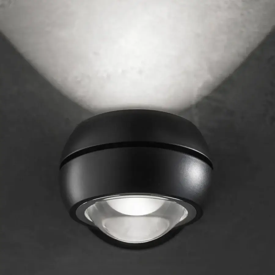 Superior Lodes Nautilus Mini wall lamp with dark matte metal and clear dome projecting focused light