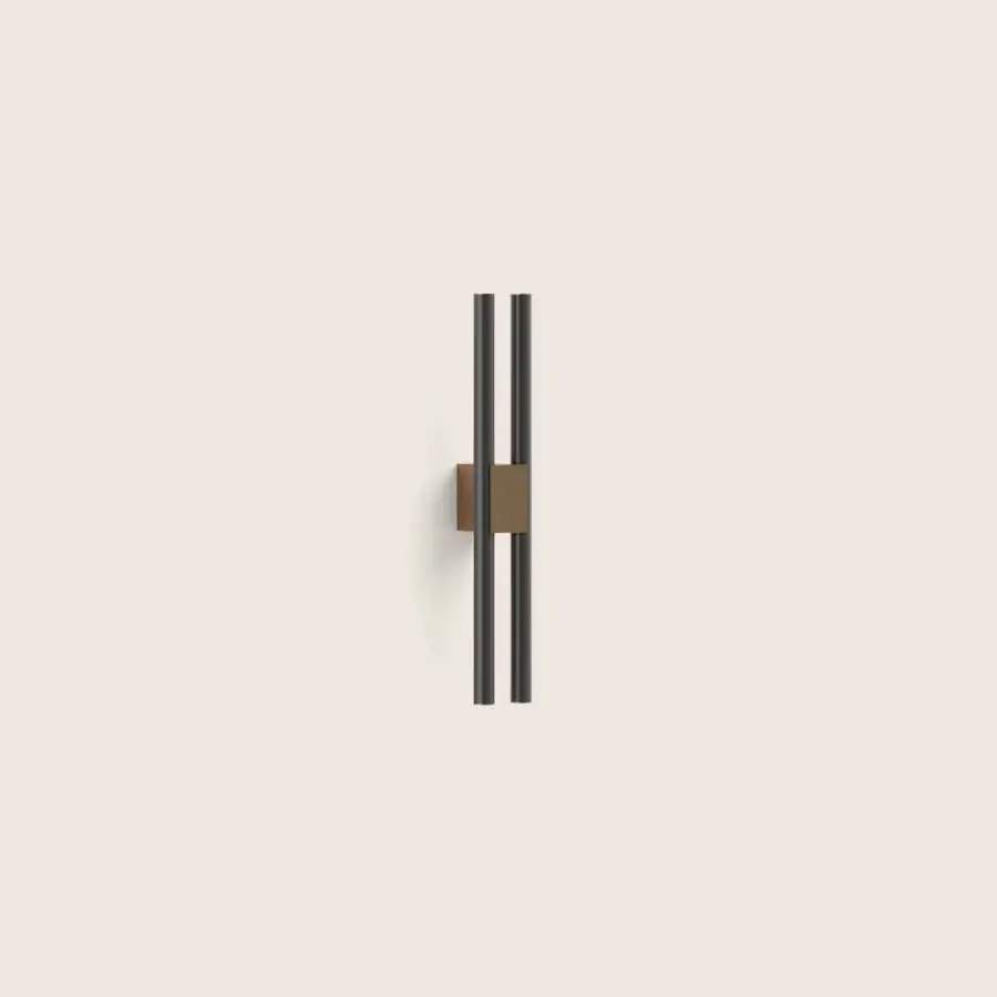 Sophisticated Paolo Castelli Fair wall lamp with elongated vertical matt black tubular metal tracks and warm bronze brass structure