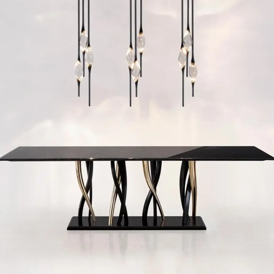 Exclusive Il Pezzo Mancante table with a black Marquinia marble top and curving supports in glossy black and metallic gold finishes